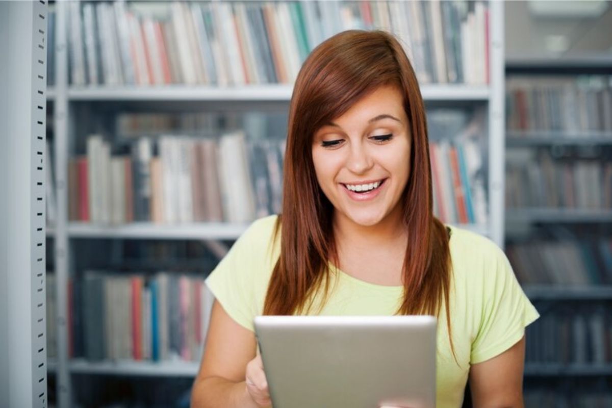 Uma estudante vendo os detalhes do curso pelo seu tablet