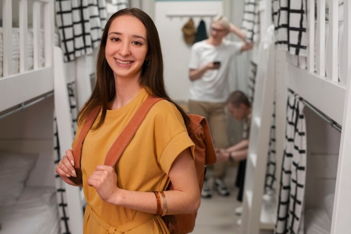 Uma estudante de camisa caramelo e mochila nas costas visitando um canil