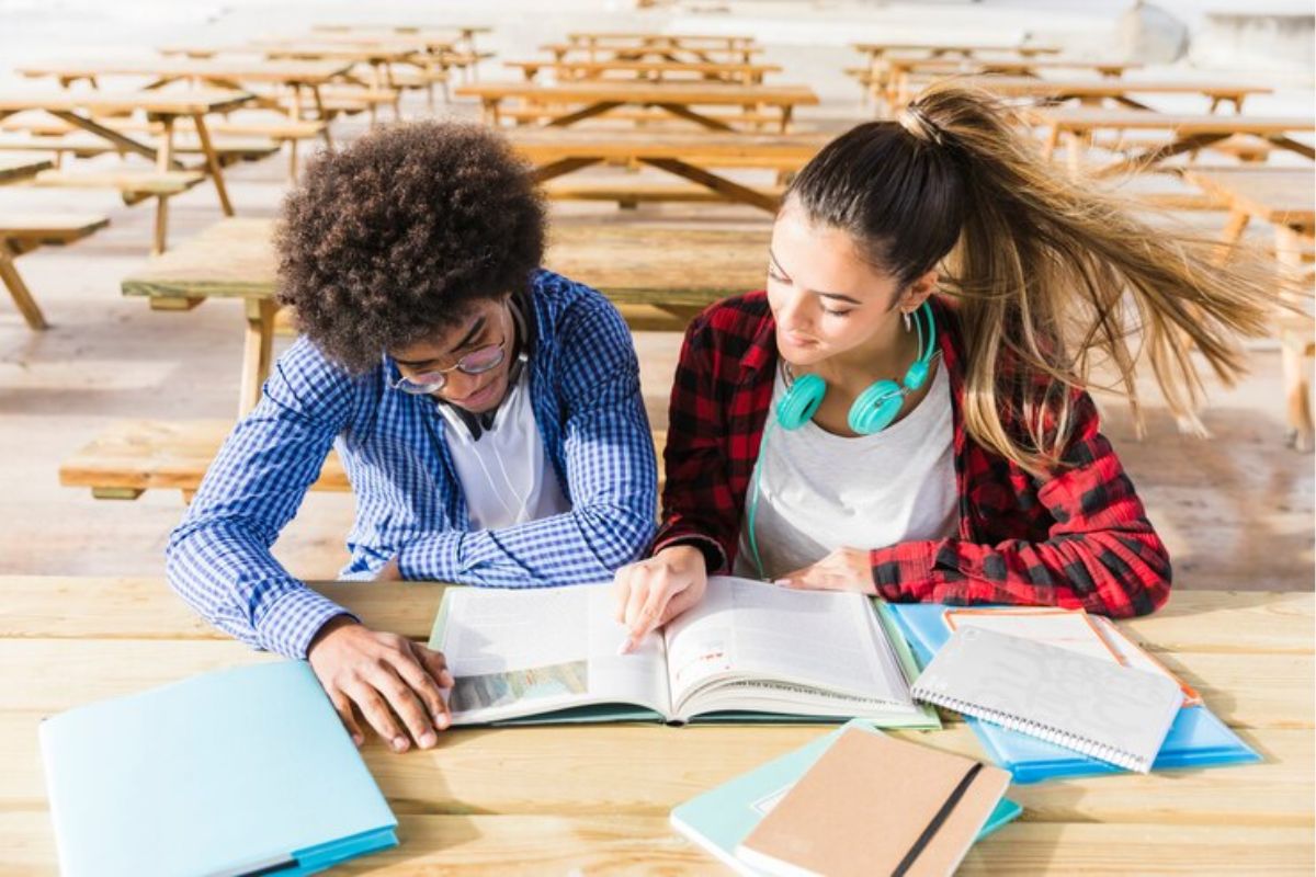 Alguns alunos estudando [vista de cima da mesa]. Eles se questionam se tem redação na prova da ETEC