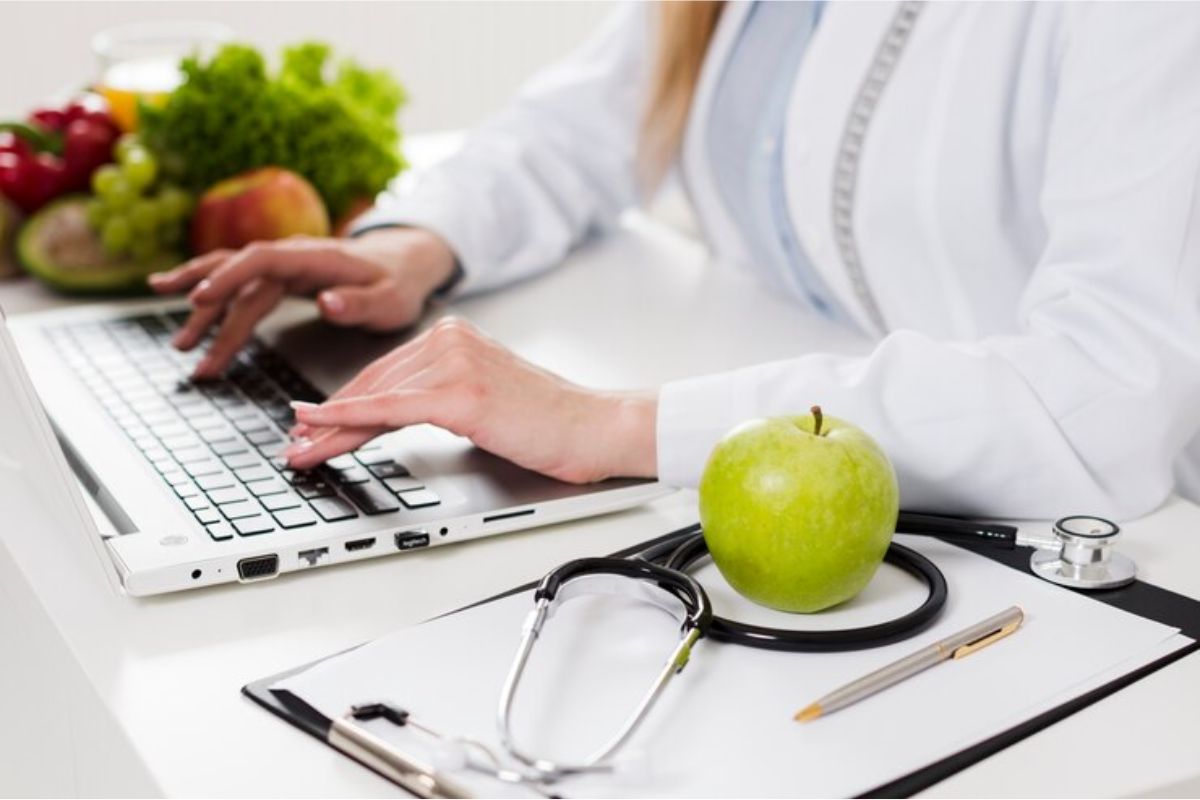 Uma profissional no consultório em frente ao seu computador vendo as informações do Curso de Nutrição e Dietética ETEC 2025